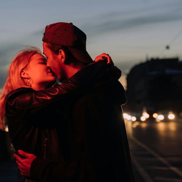 Silhouette of a man stretching against a dark, moody background.
